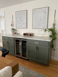 a kitchen with two paintings on the wall