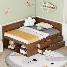 a child's bed with drawers underneath it and stuffed animals hanging on the wall