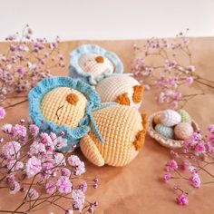 three crocheted stuffed animals sitting on top of a table next to purple flowers