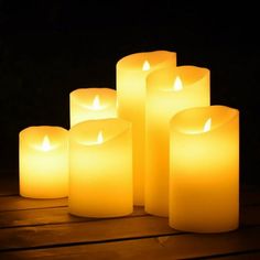 five lit candles sitting on top of a wooden table