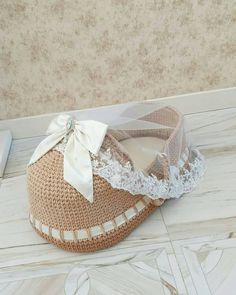 a crocheted shoe with a white bow on the top and lace around it