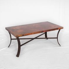 a wooden table sitting on top of a white floor next to a metal frame structure