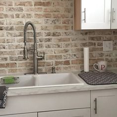 a white kitchen sink sitting under a faucet next to a counter top oven