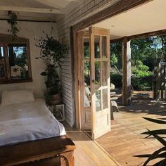 a bed sitting inside of a bedroom on top of a wooden floor next to a window