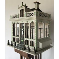 a model of a building with windows and balconies on the roof, sitting on top of a wooden table