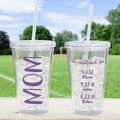 two personalized tumblers sitting on top of a wooden table next to each other