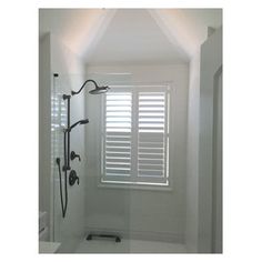 an empty bathroom with white walls and flooring is pictured in this image, the shower head has been cleaned