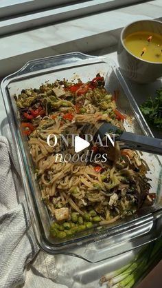 a glass dish filled with noodles and vegetables