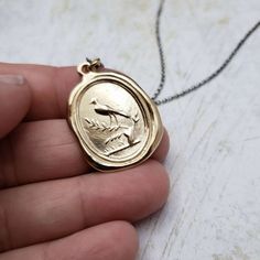 RobinHandcrafted using the impression of a late 19th century British wax seal, this pendant features the first robin of spring perched upon a sprouting branch that has sprung up from an old tree stump. The flourishing branch signifies new beginnings or a new life, while the robin is symbolic of consistency, joy & hope. Materials: Silver, Gold, Gold vermeil Gold vermeil is a thick layer of real gold over solid sterling silver, it offers the look and feel of solid gold at an affordable price.S Gold Wax Seal, First Robin, Wax Seal Pendant, Wax Seal Necklace, Chain Layering, Stacked Necklaces, Old Tree, Miami Cuban, Printed Jewelry