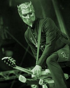 a man in black shirt playing guitar on stage