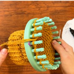 a person is holding a yarn ball and knitting needles