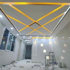 a room that is being remodeled with white walls and yellow lights on the ceiling above it