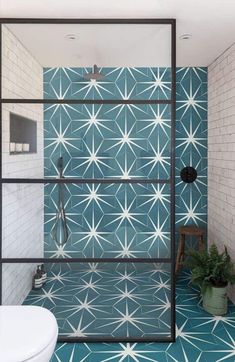 a bathroom with blue and white tiles on the walls, flooring and shower stall