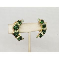 This is part of Chairish’s Costume Jewelry assortment.  1950s goldtone prong set round faux-emerald with smaller prong set round faux-peridot half moon clip earrings. Marked "Kramer." Measure: 1 1/4 inches long by 3/4 inches wide. Condition: Very good; minor wear to metal on backs.   During the 1950s Kramer also produced jewelry for Christian Dior. Retro Green Jewelry For Evening, Retro Green Jewelry For Vintage Events, Retro Green Jewelry For Anniversary, Green Retro Jewelry For Anniversary, Green Round Clip-on Earrings For Anniversary, Clip Earrings, Half Moon, Vintage 1950s, Prong Setting