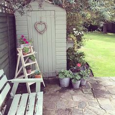 a wooden bench sitting next to a garden shed