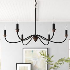 a black chandelier hanging from the ceiling in a living room with white walls