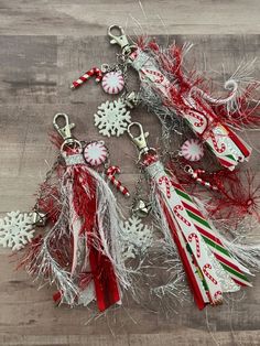 several christmas ornaments are laying on a wooden surface with snowflakes and candy canes