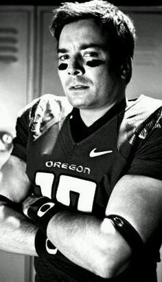 a man with his arms crossed wearing a football uniform