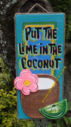 a sign that says put the lime in the coconut with a flower and a green umbrella