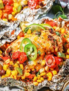 an image of chicken and corn foil packets on the grill with tomatoes, jalapenos, avocado