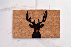 a door mat with a deer's head on it and a red dot in the middle