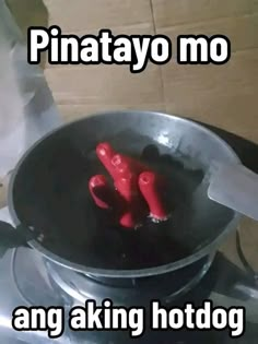 there are three red plastic people in the pot on the stove top, and one is cooking