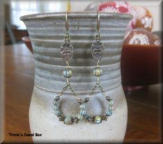 a pair of earrings sitting on top of a vase