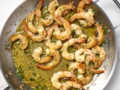 a pan filled with shrimp and sauce on top of a stove