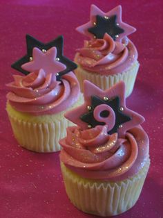 three cupcakes with pink frosting and stars on top