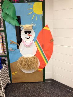 a door decorated to look like a snowman holding a surfboard and wearing sunglasses