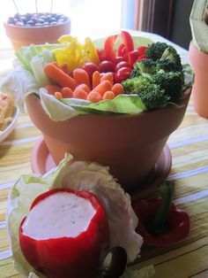 a bowl filled with lettuce, carrots and other vegetables on a table