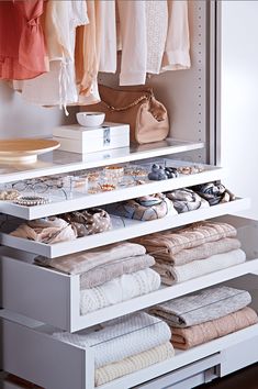 an organized closet with folded clothes and handbags