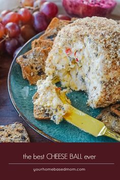 the best cheese ball ever on a plate with crackers and grapes