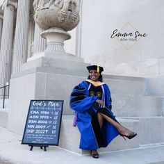 a woman in graduation gown sitting on steps