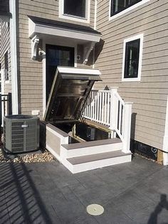 an air conditioner is open in front of a house with stairs leading up to it