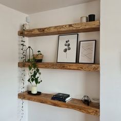 two wooden shelves with plants and pictures on them