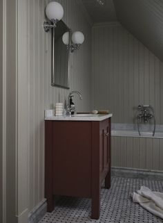 a bathroom with a sink, mirror and bathtub in the corner next to it