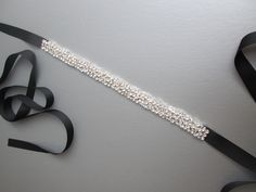 "This belt is made with Swarovski crystals and silver wire neatly twisted to form this unique floating effect crystal belt. The belt measures 7/8\" wide and 13\" long and is tied in the back with ribbons. The entire sash with the ribbons measures 150\" long. Available in gold, silver and rose gold finish and with a variety of ribbon options. - This belt can be made in any length, please inquire about the specific length and pricing - Shown in the photos in silver finish with black grosgrain ribb Adjustable Formal Sash Belt, Elegant Adjustable Belt For Evening, Elegant Adjustable Sash For Formal Occasions, Elegant Adjustable Sashes For Formal Occasions, Elegant Formal Adjustable Sash, Elegant Formal Adjustable Sashes, Adjustable Rhinestone Party Belts, Silver Embroidered Belt Sash For Party, Elegant Adjustable Embroidered Belt