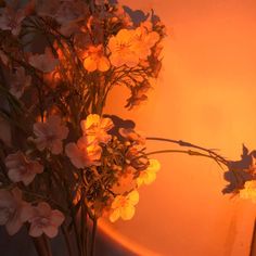 a vase filled with lots of flowers on top of a wooden table next to a wall