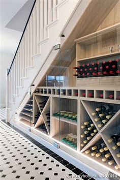 a wine cellar under the stairs in a house