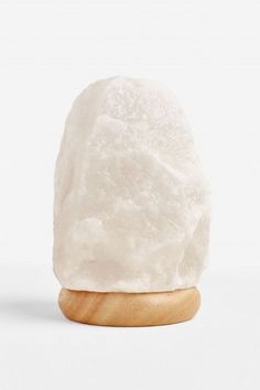 a white rock sitting on top of a wooden stand