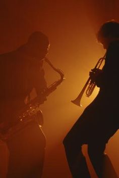 two men are playing instruments in the dark