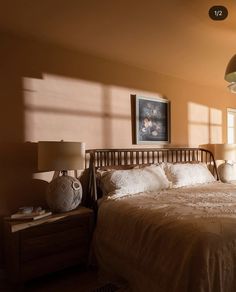 a bed sitting in a bedroom next to two lamps on either side of the bed