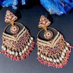 Featuring a pair of chandbali earrings made on sterling silver with gold plated. The studded stones comprise pearls and ruby like red stones. The hanging beads comprise freshwater pearls and natural ruby beads. The earrings close with a bombay screw. Mughal Jewellery, 22k Gold Jewelry Necklaces, Mughal Jewelry, Ruby And Pearl, 22k Gold Jewelry, Hanging Beads, Red Stones, Chandbali Earrings, Pearl Necklace Set