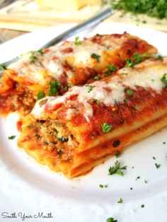 two slices of lasagna on a white plate with parsley and seasoning