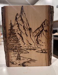 a wooden block with a mountain scene on it