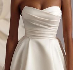 a woman wearing a strapless white wedding dress