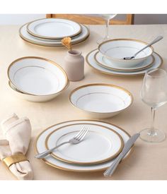 the table is set with white and gold plates