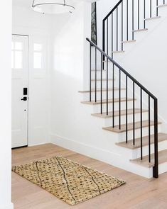 a stair case next to a white door and wooden floor