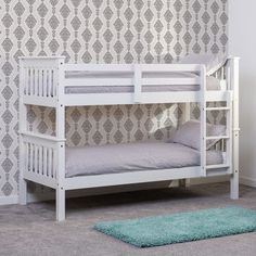 a white bunk bed sitting on top of a carpeted floor next to a wall